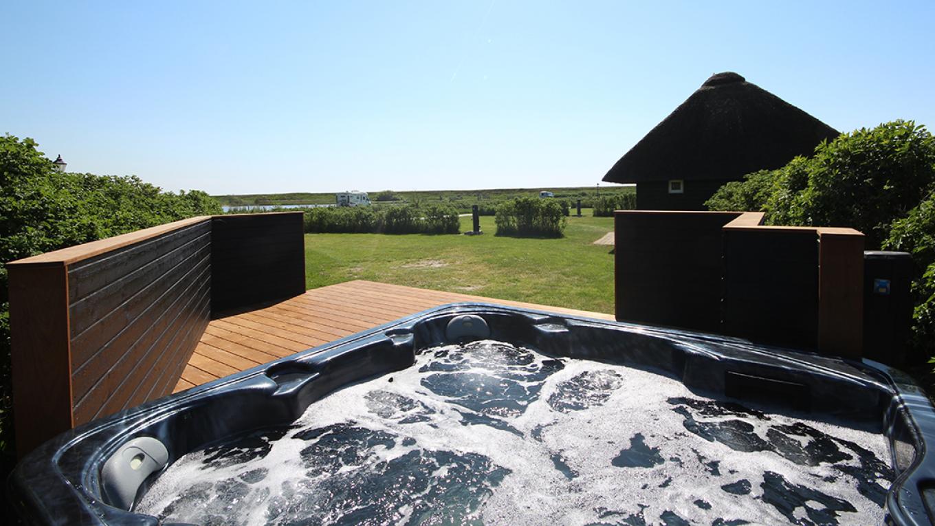 Hvidbjerg Strand Feriepark har nu fået seks stjerner. Her ses en XL Luksusplads med udendørs spa. Hvidbjerg Strand Feriepark