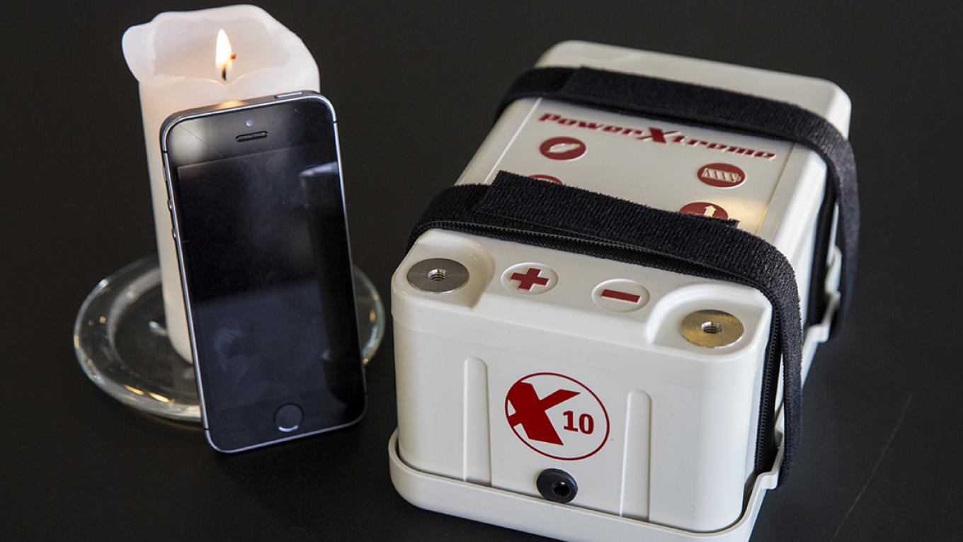 Størrelsesforholdet på batteriet kan fornemmes, når det sammenlignes med en smartphone. Batteri, PowerXtreme X10, campingudstyr