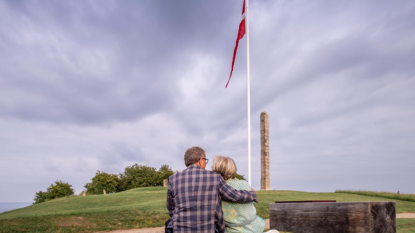 SKAMLINGSBANKEN /Museum Kolding Billede af par der sidder foran Dannebrog