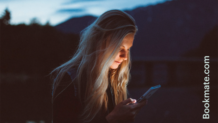 Billede af person som læser bog på mobiltelefon