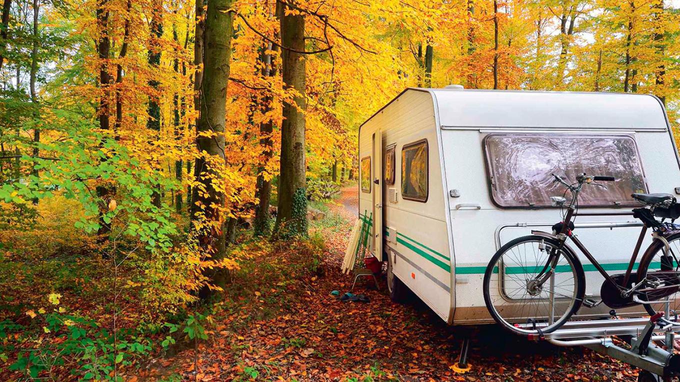 Sæsonafslutning, nedpakning af campingvogn, pak vognen væk, campingvogn i skov, efterår